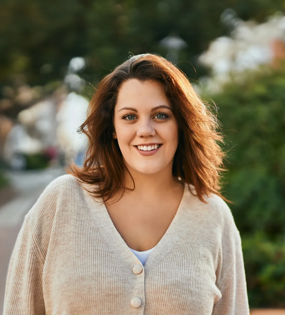 A woman with brown hair smiling while on a walk.