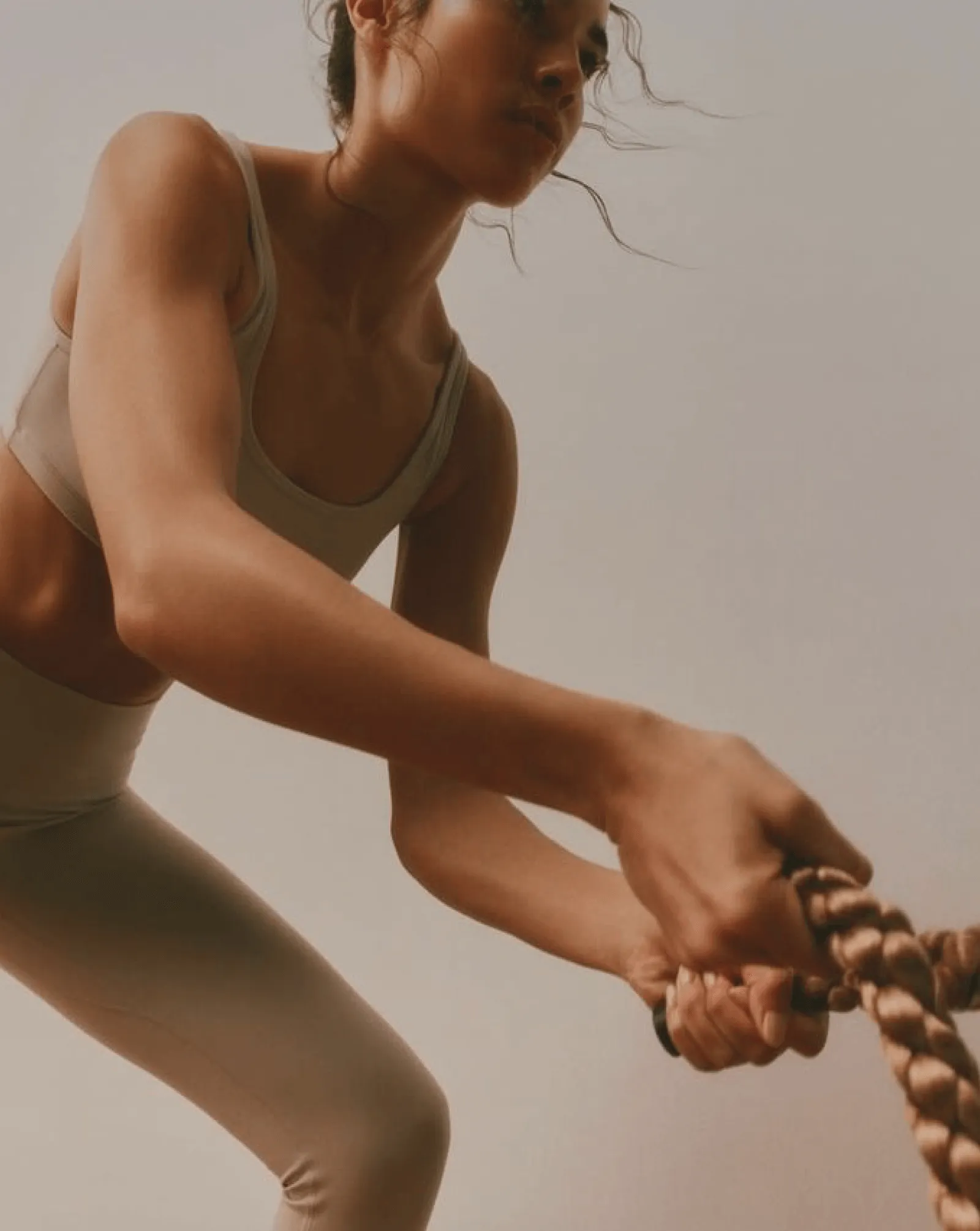 A close up of a woman using workout ropes